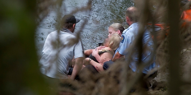 Police officers with the woman after she was taken to shore. Photo / Christine Cornege Police officers with the woman after she was taken to shore. Photo / Christine Cornege