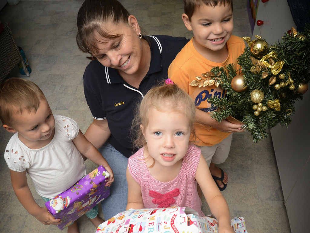 HELPING OTHERS: Education Leader at Cubby House For Kids Janelle Grory (back) with Olivia Lewis, Ella Darlington and Patrick Yuke hold presents for their ‘giving tree’ to go towards Christmas presents for the Bunya Childcare Centre in Winmalee. Photo: Adam Hourigan HELPING OTHERS: Education Leader at Cubby House For Kids Janelle Grory (back) with Olivia Lewis, Ella Darlington and Patrick Yuke hold presents for their ‘giving tree’ to go towards Christmas presents for the Bunya Childcare Centre in Winmalee. Photo: Adam Hourigan