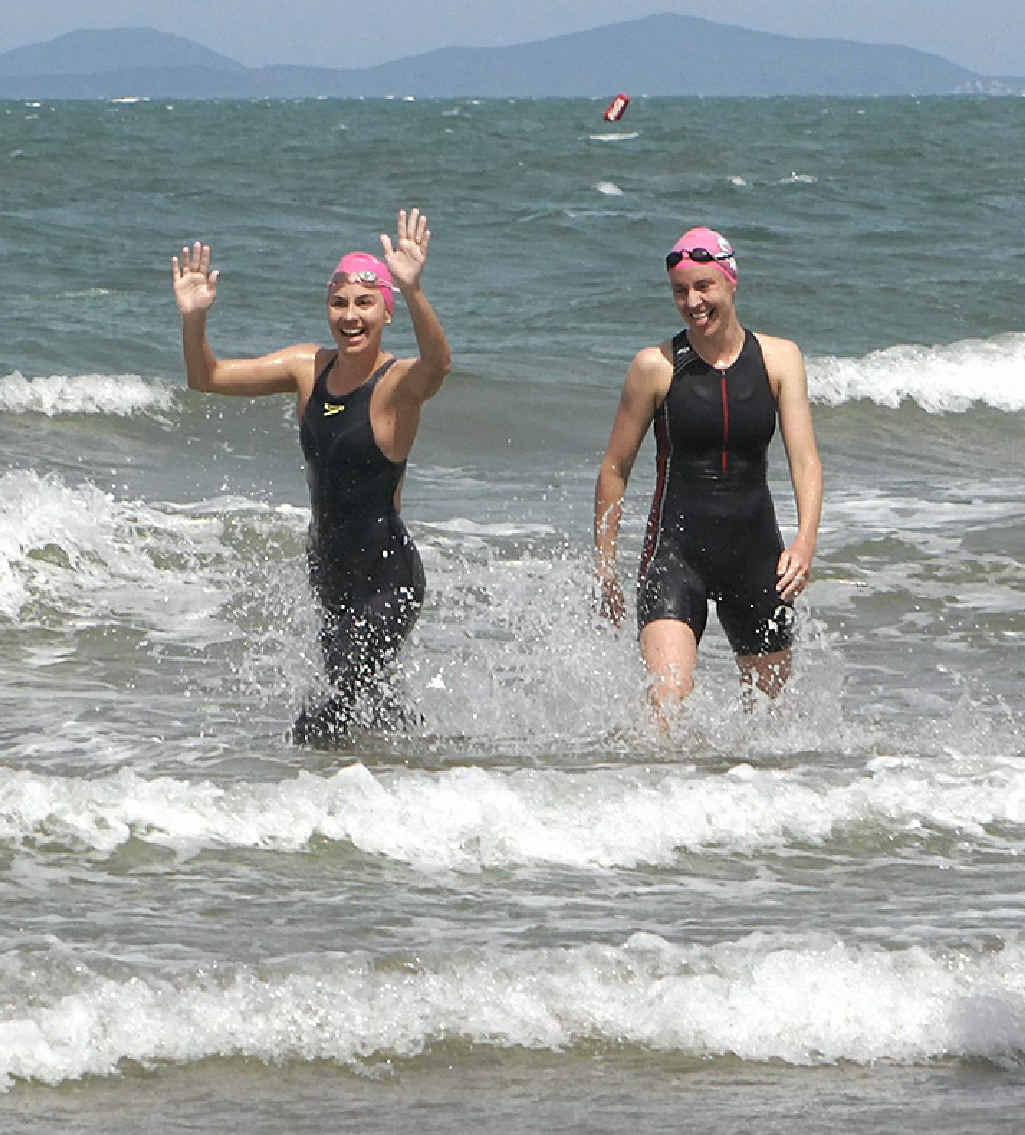 SWEET SUCCESS: Sisters Claire Finter (left) and Jayne Moyle emerge from the water after completing their gruelling charity swim from Great Keppel Island to Yeppoon. INSET: Jayne Moyle (front) and sister Claire Finter power through the water on their way to Yeppoon, accompanied by Claire’s husband Daniel. SWEET SUCCESS: Sisters Claire Finter (left) and Jayne Moyle emerge from the water after completing their gruelling charity swim from Great Keppel Island to Yeppoon. INSET: Jayne Moyle (front) and sister Claire Finter power through the water on their way to Yeppoon, accompanied by Claire’s husband Daniel.