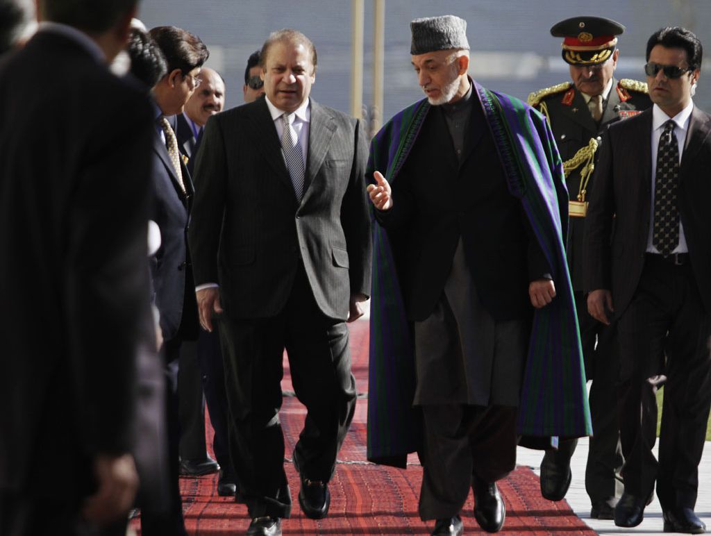 Afghan President Hamid Karzai, center right, talks with Pakistan's Prime Minister Nawaz Sharif while they inspect a guard of honor in Kabul, Afghanistan, Saturday, Nov, 2013. Sharif said Saturday that the recent release of a senior Taliban leader shows he is committed to helping bring peace to Afghanistan. Afghan President Hamid Karzai, center right, talks with Pakistan's Prime Minister Nawaz Sharif while they inspect a guard of honor in Kabul, Afghanistan, Saturday, Nov, 2013. Sharif said Saturday that the recent release of a senior Taliban leader shows he is committed to helping bring peace to Afghanistan.