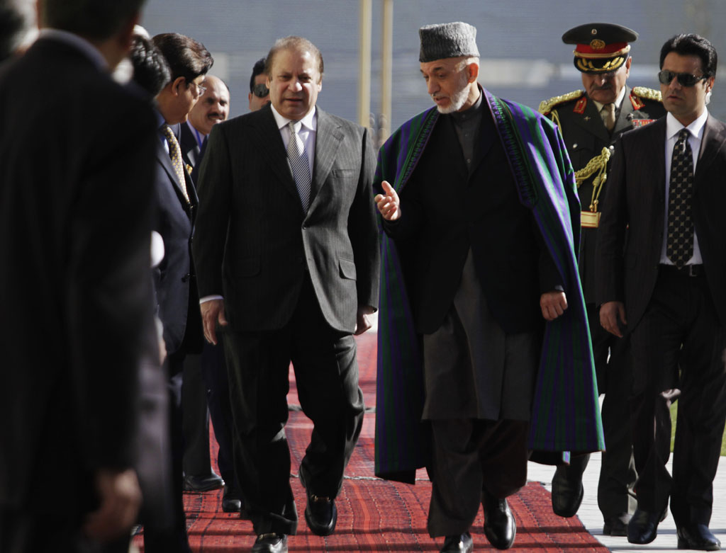 Afghan President Hamid Karzai, center right, talks with Pakistan's Prime Minister Nawaz Sharif while they inspect a guard of honor in Kabul, Afghanistan, Saturday, Nov, 2013. Sharif said Saturday that the recent release of a senior Taliban leader shows he is committed to helping bring peace to Afghanistan. Afghan President Hamid Karzai, center right, talks with Pakistan's Prime Minister Nawaz Sharif while they inspect a guard of honor in Kabul, Afghanistan, Saturday, Nov, 2013. Sharif said Saturday that the recent release of a senior Taliban leader shows he is committed to helping bring peace to Afghanistan.