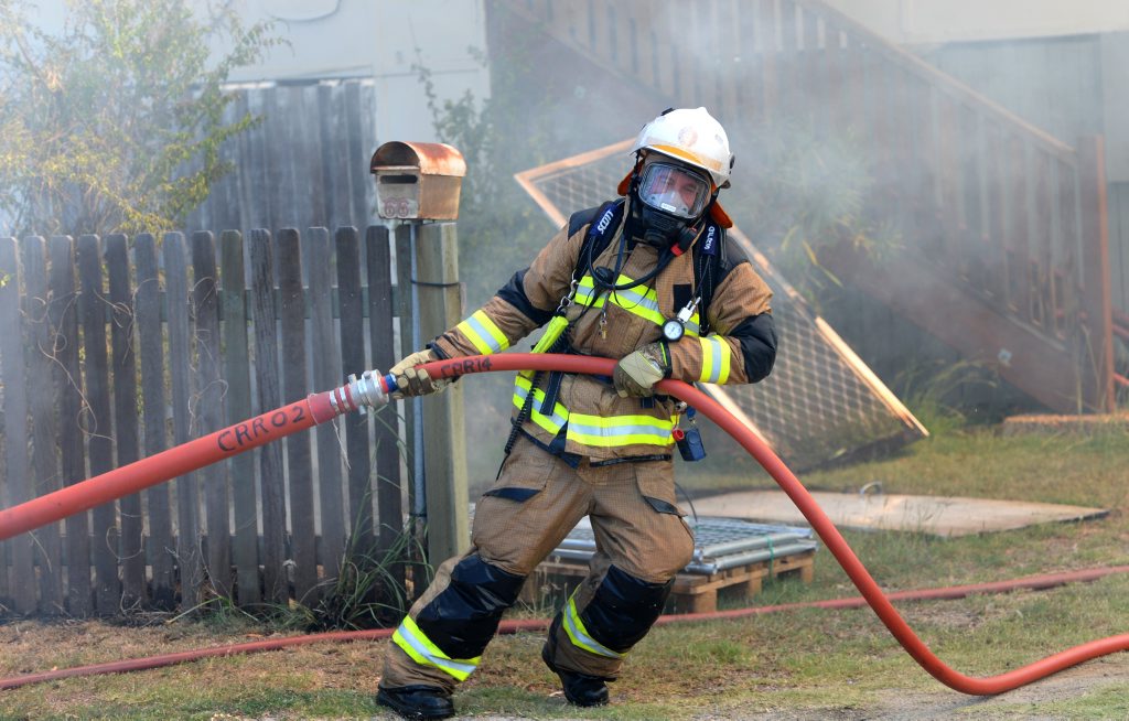 Rockhampton firefighters work to extinguish a house fire. Rockhampton firefighters work to extinguish a house fire.
