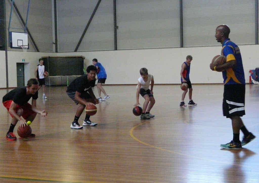 HANDS-ON: Coach Jay Washington leads the junior basketballers through dribbling skills at Raymond Laurie Sports Centre in Yamba. PHOTO: CONTRIBUTED HANDS-ON: Coach Jay Washington leads the junior basketballers through dribbling skills at Raymond Laurie Sports Centre in Yamba. PHOTO: CONTRIBUTED