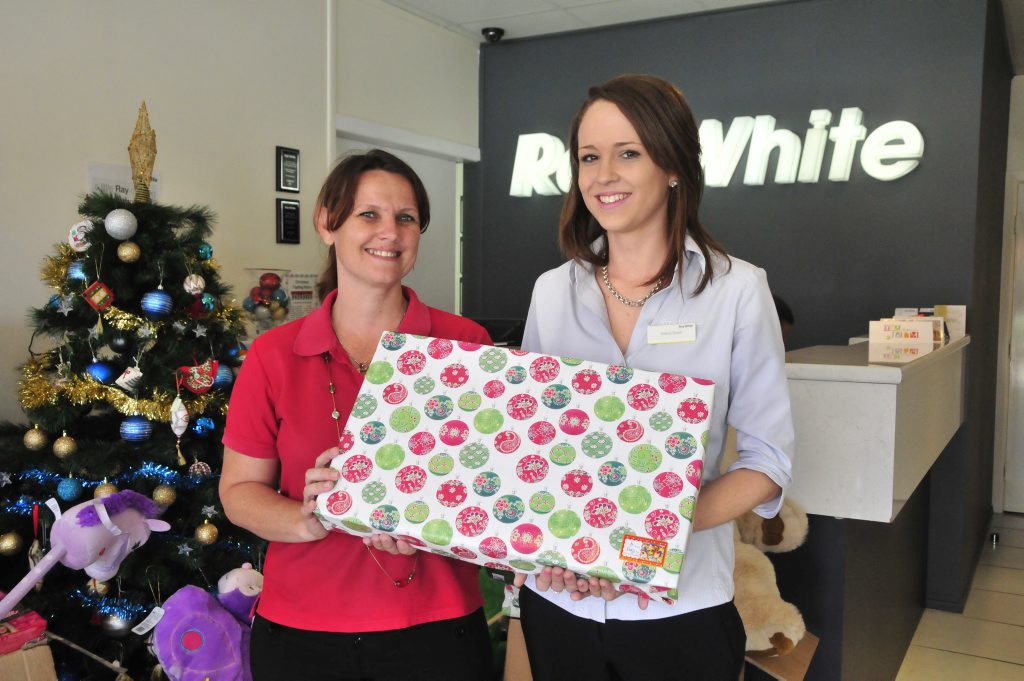 COMMUNITY SPIRIT: Linda Tighe (left) from UnitingCare Communities receives a donation from Ray White’s Emma Grant as part of their Christmas appeal. COMMUNITY SPIRIT: Linda Tighe (left) from UnitingCare Communities receives a donation from Ray White’s Emma Grant as part of their Christmas appeal.