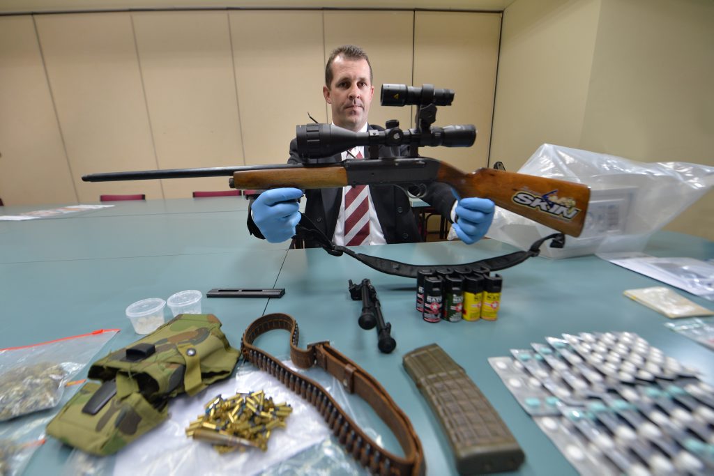 Detective Senior Sergeant Luke Peachy with a semi-automatic weapon found among other items and drugs seized during two separate raids in August. Detective Senior Sergeant Luke Peachy with a semi-automatic weapon found among other items and drugs seized during two separate raids in August.