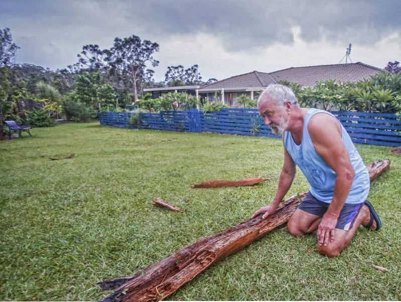 NARROW ESCAPE: Graham Goscombe, of Gulmarrad, with some of the shrapnel thrown through his backyard when a tree was hit by lightning. PHOTO: ADAM HOURIGAN NARROW ESCAPE: Graham Goscombe, of Gulmarrad, with some of the shrapnel thrown through his backyard when a tree was hit by lightning. PHOTO: ADAM HOURIGAN