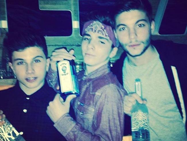 Rocco Ritchie (centre) holding a bottle of gin. Rocco Ritchie (centre) holding a bottle of gin.