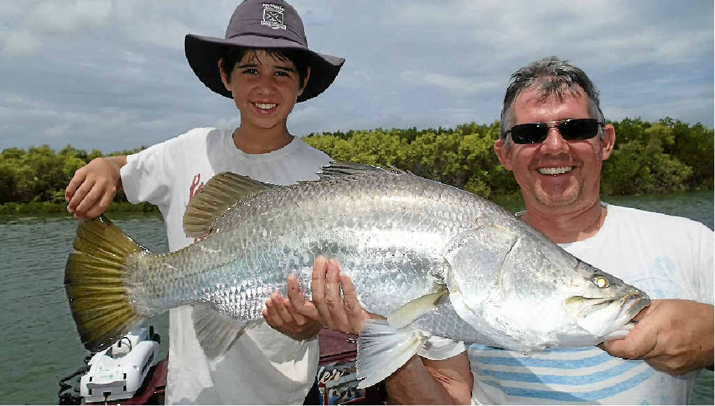 Tony Mitchell and son Matthew holding an 90cm barra. Tony Mitchell and son Matthew holding an 90cm barra.