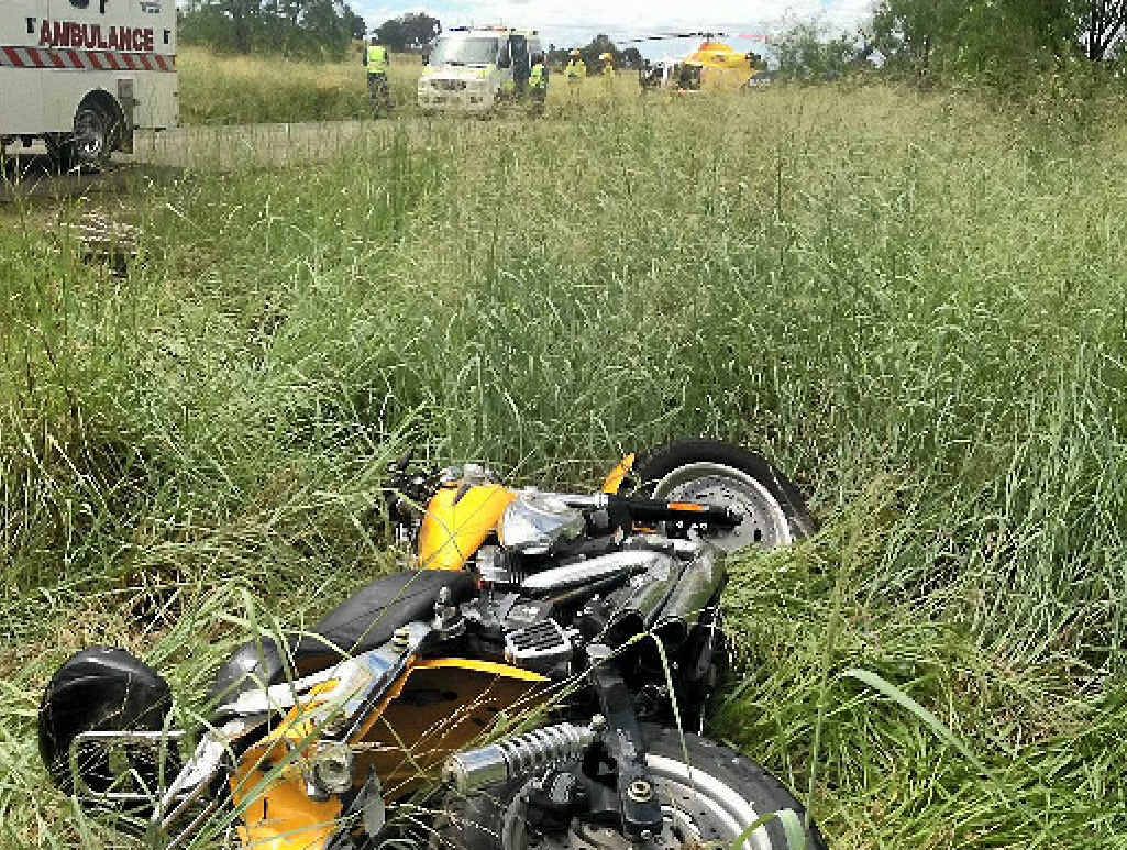 A motorcycle lies in grass on the side of the road at Banana as a rider receives attention from the RACQ Capricorn Helicopter Rescue medical doctor. A motorcycle lies in grass on the side of the road at Banana as a rider receives attention from the RACQ Capricorn Helicopter Rescue medical doctor.