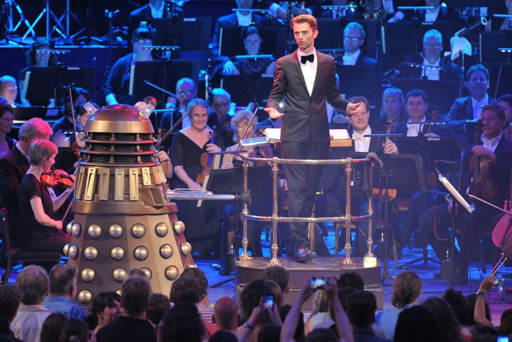 Conductor Ben Foster in a scene from the Doctor Who Symphonic Spectacular in the UK. Conductor Ben Foster in a scene from the Doctor Who Symphonic Spectacular in the UK.