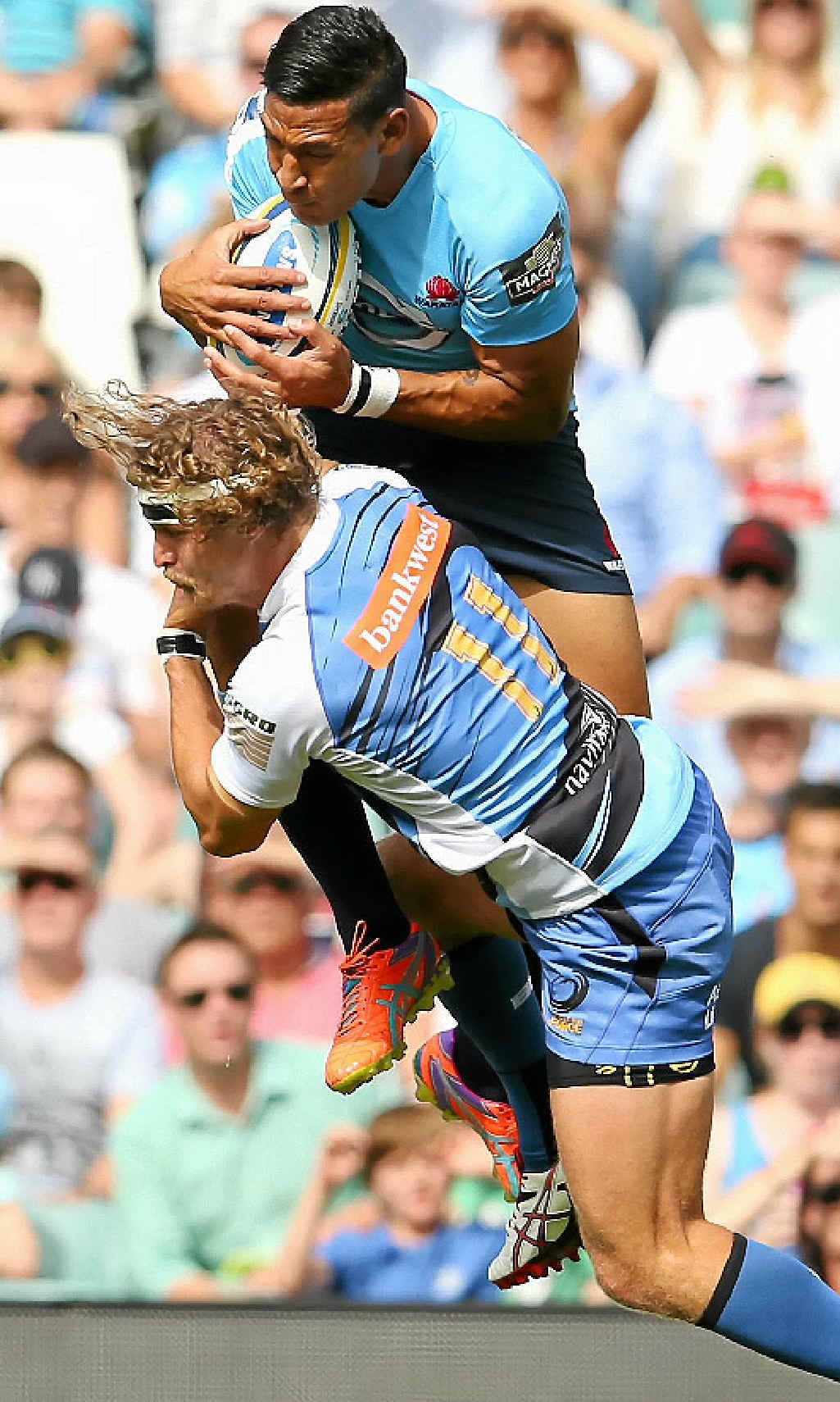 OVER AND IN: Israel Folau, of the Waratahs, wins the high ball over Nick Cummins, of the Force, at Allianz Stadium yesterday. OVER AND IN: Israel Folau, of the Waratahs, wins the high ball over Nick Cummins, of the Force, at Allianz Stadium yesterday.