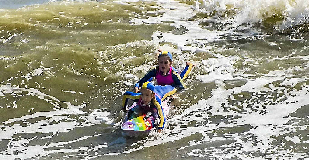 GAINING KNOWLEDGE: Sophie Duff, 10, and Paris Richardson, 10, battle a large swell during rescue training for Tannum Sands Nippers. GAINING KNOWLEDGE: Sophie Duff, 10, and Paris Richardson, 10, battle a large swell during rescue training for Tannum Sands Nippers.
