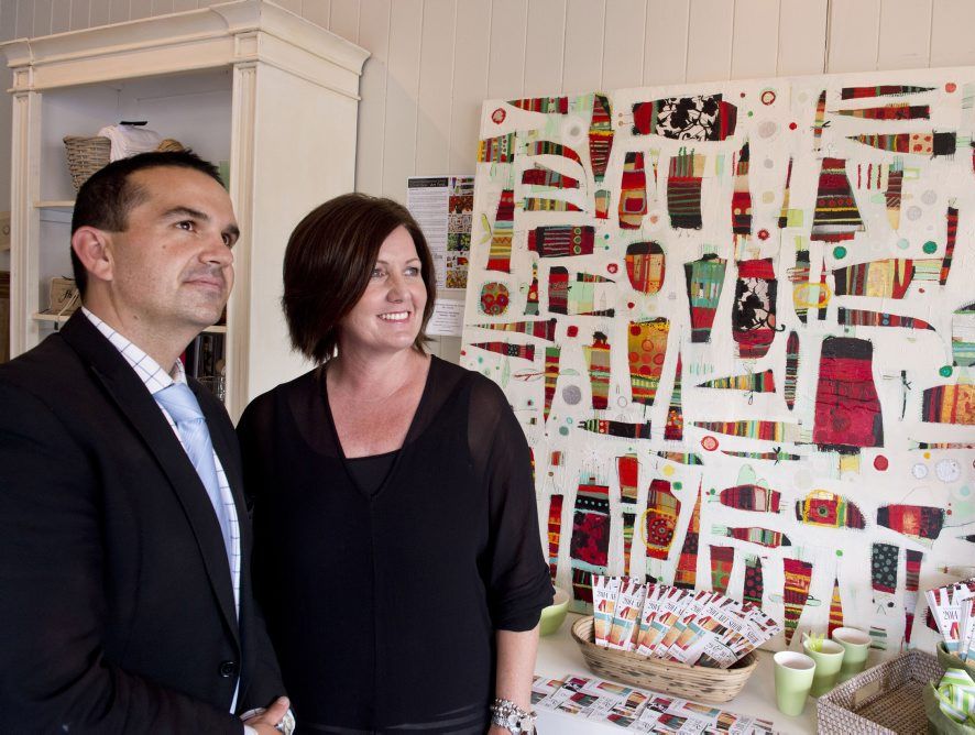 ( from left ) Scott Allison ( Southern Cross BMW ) and Jo Mills from French Allure with an artwork by Heidi Tansey. Part of the art trail for the Toowoomba Grammar Art Show.. Photo Nev Madsen / The Chronicle