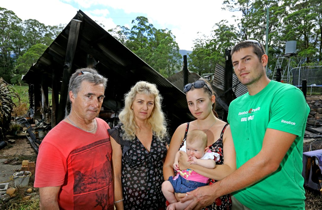 Terry, Jenelle and Arenea Norris with her boyfriend Crusoe Bower and daughter Lyla at what remains of their burnt down house at Pumpenbil. Terry, Jenelle and Arenea Norris with her boyfriend Crusoe Bower and daughter Lyla at what remains of their burnt down house at Pumpenbil.