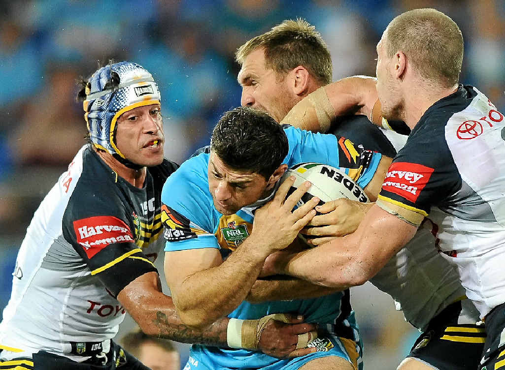 WRAPPED UP: Mark Minichiello of the Titans is tackled by North Queensland Cowboys players at Cbus Super Stadium on the Gold Coast last night. WRAPPED UP: Mark Minichiello of the Titans is tackled by North Queensland Cowboys players at Cbus Super Stadium on the Gold Coast last night.