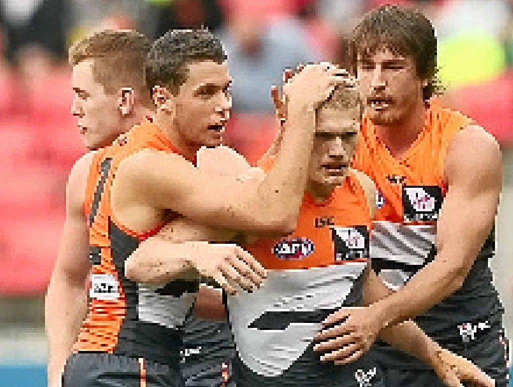 Giants midfielder Adam Treloar is congratulated by his teammates after kicking a goal against Melbourne.