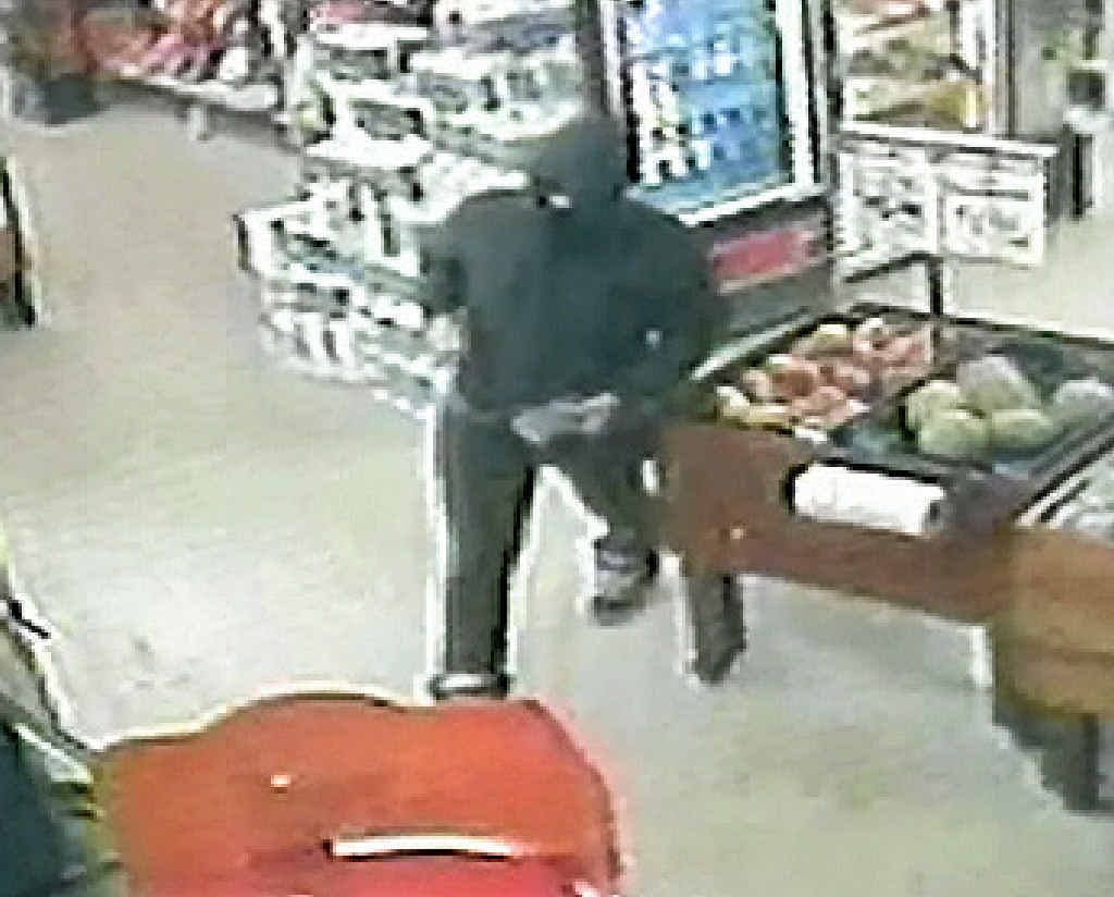 CCTV footage of an armed gunman police are seeking following a robbery at a Gladstone supermarket on Monday night. CCTV footage of an armed gunman police are seeking following a robbery at a Gladstone supermarket on Monday night.