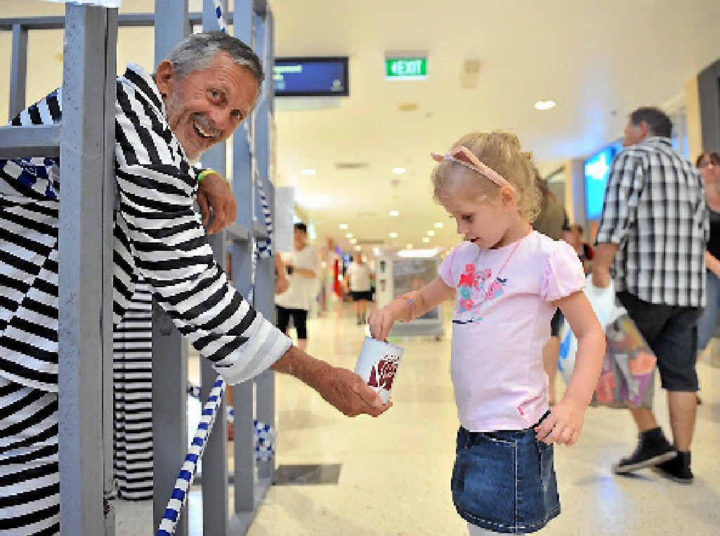 Imogen Stoneley, 4, helps community member Mac Hosking raise bail after he was locked in a mock jail. Imogen Stoneley, 4, helps community member Mac Hosking raise bail after he was locked in a mock jail.