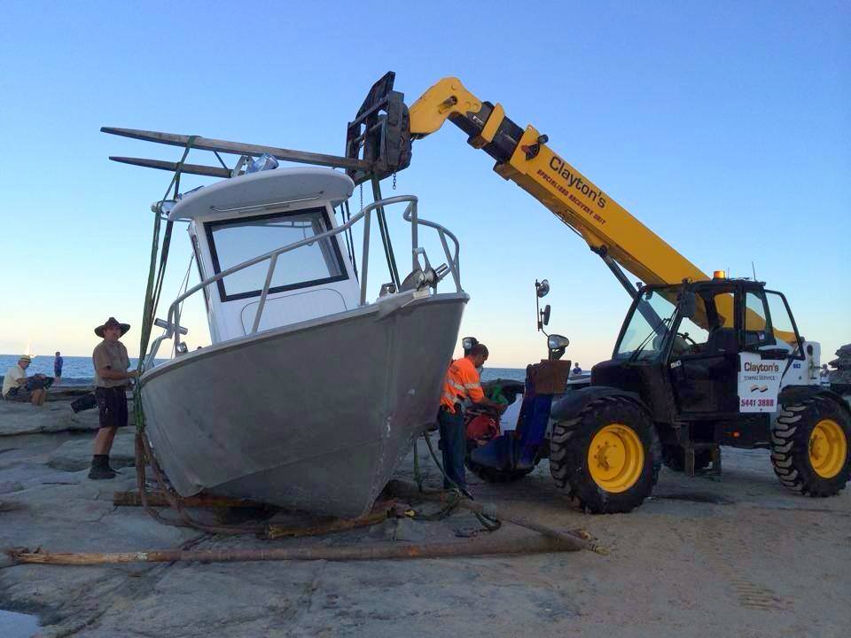 A Clayton's Towing crew recovers a boat off the rocks at Pt Cartwright on Monday. Photo: Clayton's Towing A Clayton's Towing crew recovers a boat off the rocks at Pt Cartwright on Monday. Photo: Clayton's Towing