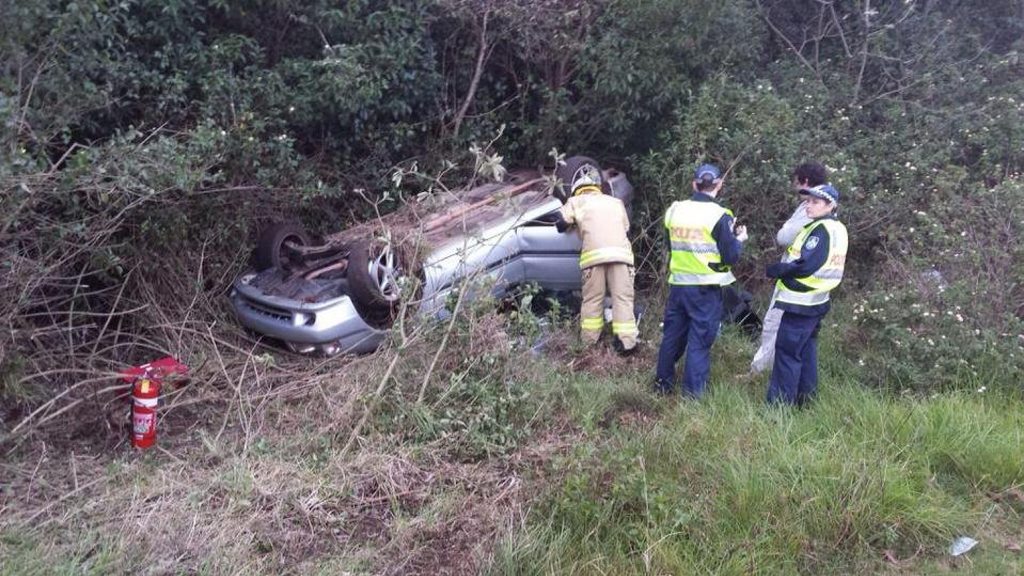 Emergency services inspect a vehicle which rolled down an embankment beside the New England Hwy at Blue Mountain Heights. Emergency services inspect a vehicle which rolled down an embankment beside the New England Hwy at Blue Mountain Heights.