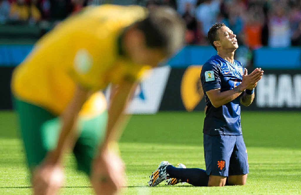 Memphis Depay, of the Netherlands, celebrates his team’s victory while an Australian player bows his head after the game in Porto Alegre. Memphis Depay, of the Netherlands, celebrates his team’s victory while an Australian player bows his head after the game in Porto Alegre.
