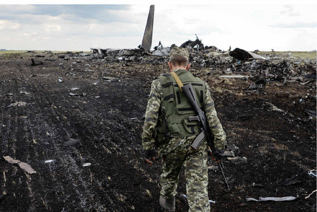 WAR ZONE: A soldier surveys the wreckage of a Ukraine Air Force transport plane shot down as it was approaching Luhansk airport, killing 49 people. WAR ZONE: A soldier surveys the wreckage of a Ukraine Air Force transport plane shot down as it was approaching Luhansk airport, killing 49 people.