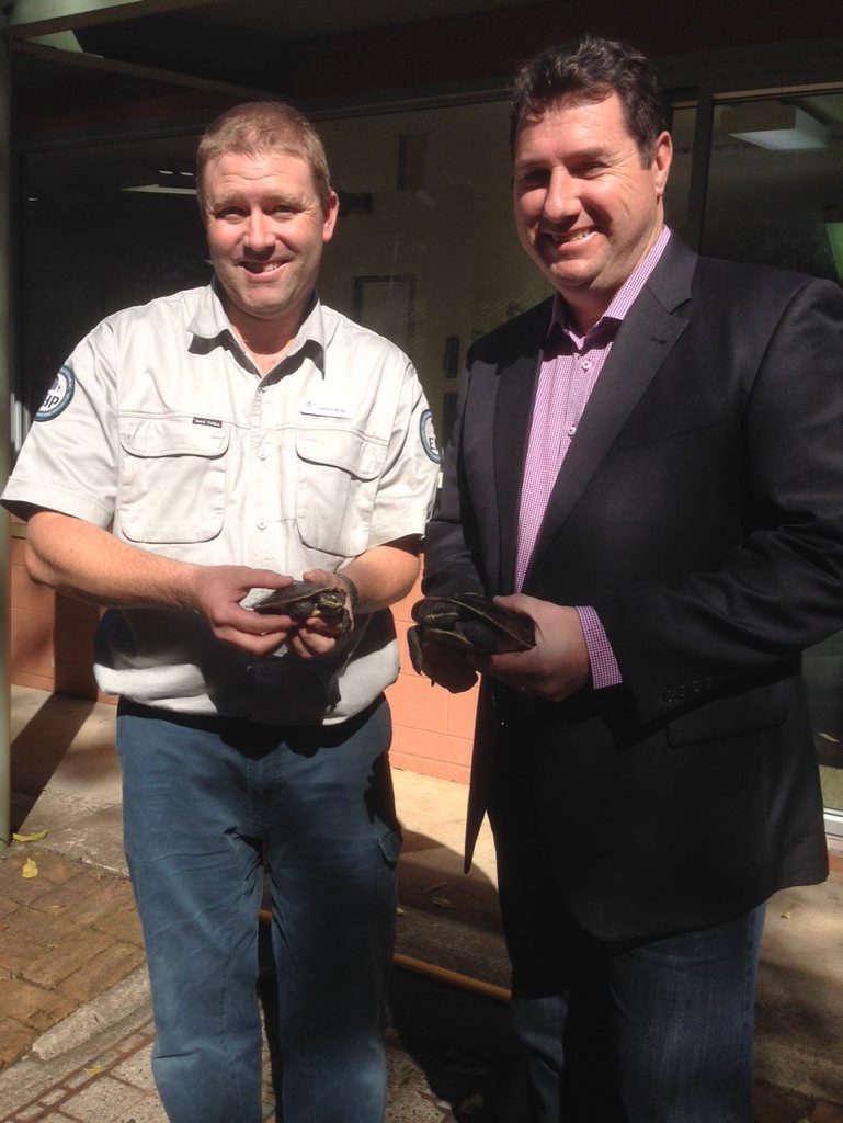 Environment Minister Andrew Powell (right) and wildlife officer Cameron Wregg, pictured with a turtle, talk about a wildlife crime crackdown. Photo: contributed. Environment Minister Andrew Powell (right) and wildlife officer Cameron Wregg, pictured with a turtle, talk about a wildlife crime crackdown. Photo: contributed.