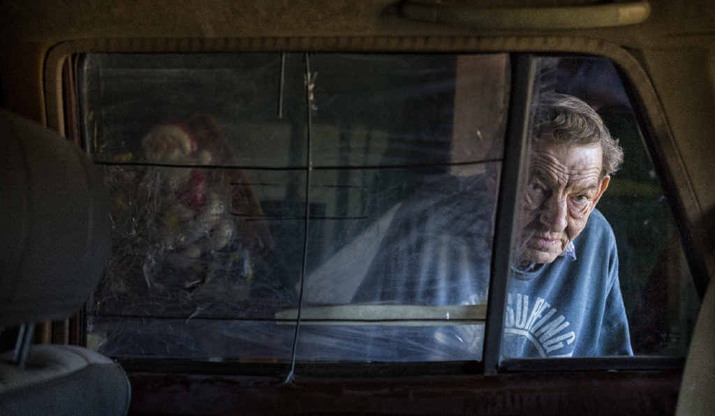 FEELS LOUSY: Kevin Robards looks through the plastic covered window of his car that has been repeatedly smashed and broken into.