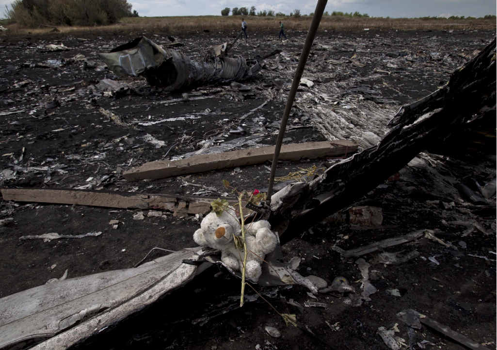 A toy bear is placed on charred plane fuselage parts, as people walk through the crash site of Malaysia Airlines Flight 17 near the village of Hrabove, eastern Ukraine. A toy bear is placed on charred plane fuselage parts, as people walk through the crash site of Malaysia Airlines Flight 17 near the village of Hrabove, eastern Ukraine.