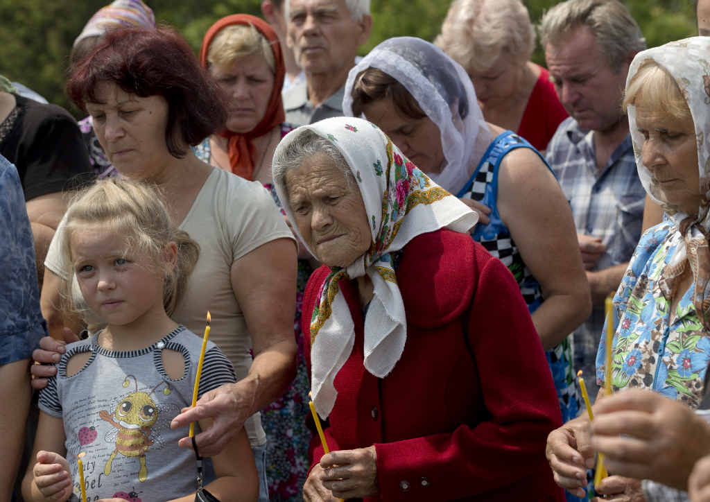 A women cries during a religious service held by villagers in memory of the victims at the crash site of Malaysia Airlines Flight 17, near the village of Hrabove, eastern Ukraine. A women cries during a religious service held by villagers in memory of the victims at the crash site of Malaysia Airlines Flight 17, near the village of Hrabove, eastern Ukraine.