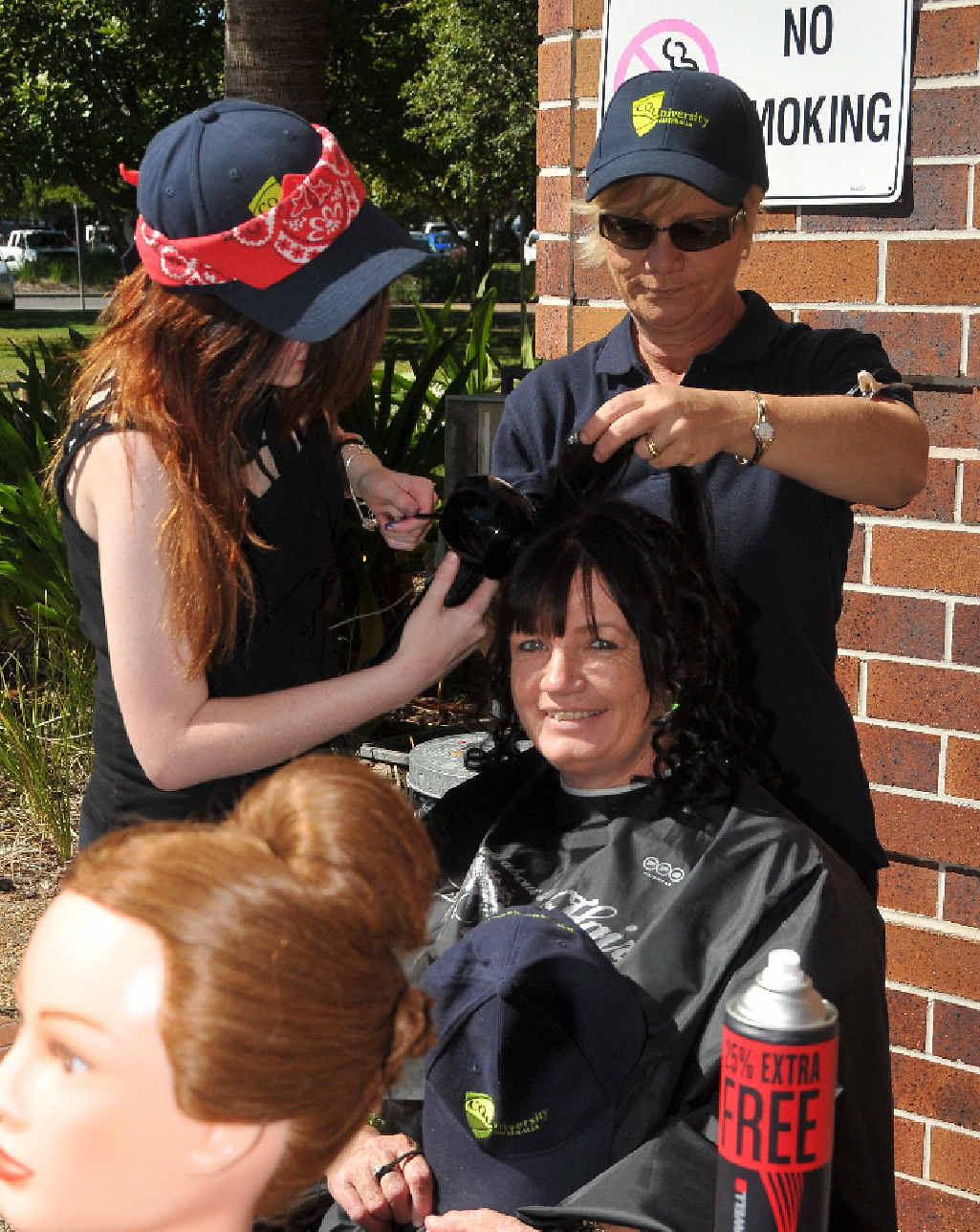 CQUniversity senior campus administrator Alison Murdoch gets her hair done by student Caitlin Williams and teacher Louise Stakenburg. CQUniversity senior campus administrator Alison Murdoch gets her hair done by student Caitlin Williams and teacher Louise Stakenburg.