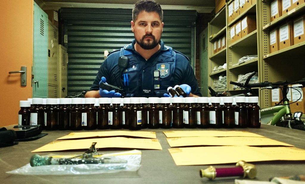 DRUG HAUL: Constable Carl Newman with 191 vials of methadone, a knuckle-duster/taser and drug paraphernalia that were seized in the raid. DRUG HAUL: Constable Carl Newman with 191 vials of methadone, a knuckle-duster/taser and drug paraphernalia that were seized in the raid.