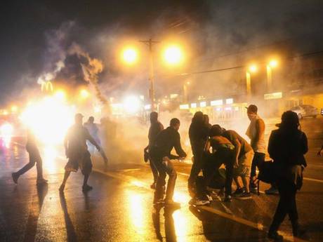 Police fire tear gas at demonstrators protesting the shooting of Michael Brown after they refused to honor the midnight curfew Police fire tear gas at demonstrators protesting the shooting of Michael Brown after they refused to honor the midnight curfew
