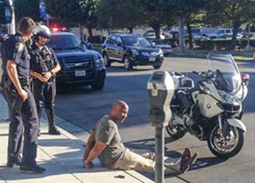A photo of Charles Belk being detained by police on Friday 22 August A photo of Charles Belk being detained by police on Friday 22 August