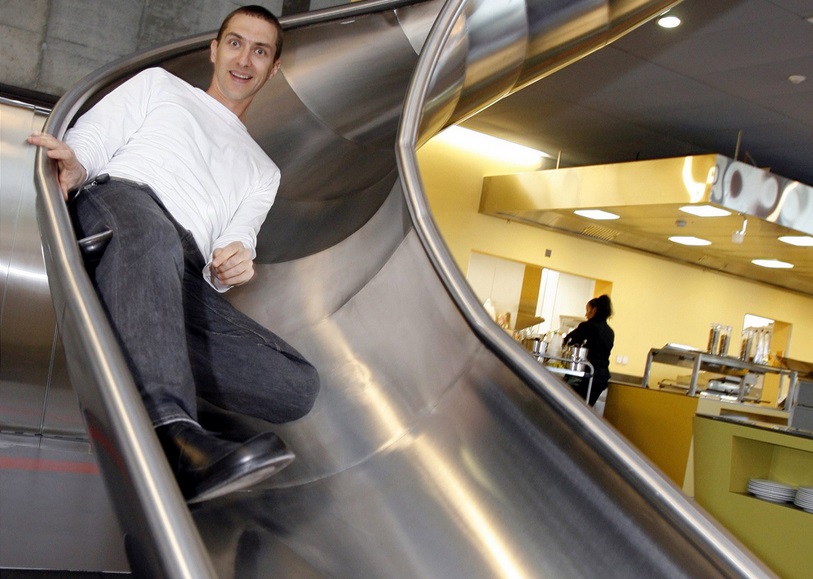 A Google worker uses the company slide on the way to the canteen A Google worker uses the company slide on the way to the canteen