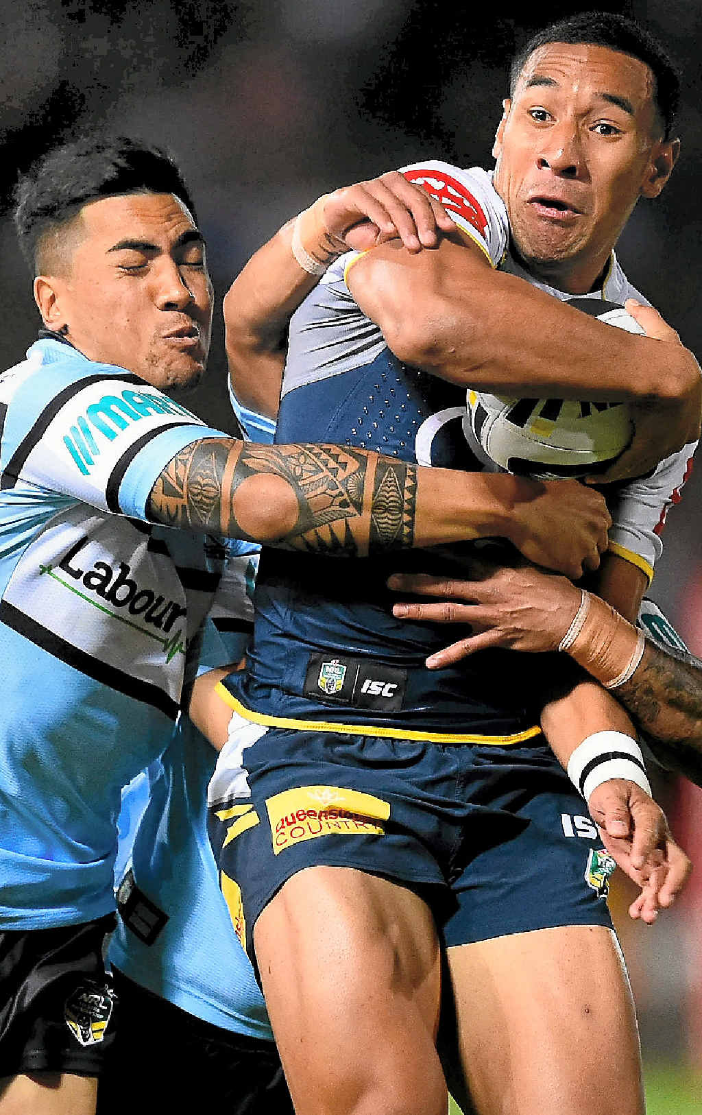 Tautau Moga of the Cowboys is tackled by Sosaia Feki and Ricky Leutele of the Sharks in Townsville last night. Tautau Moga of the Cowboys is tackled by Sosaia Feki and Ricky Leutele of the Sharks in Townsville last night.