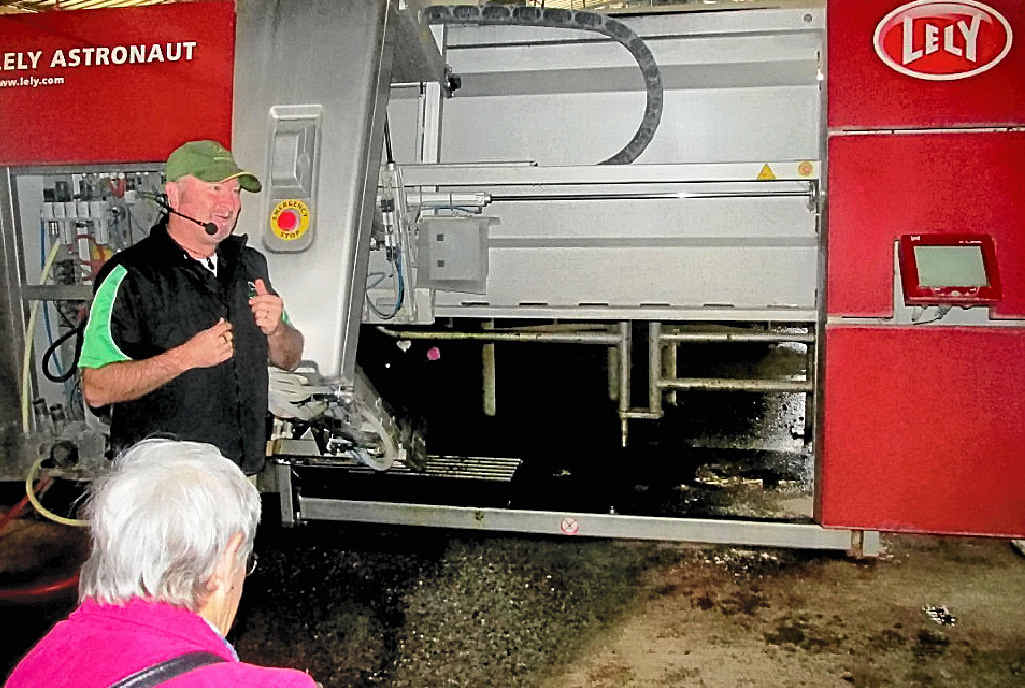 NEW WAY: Greg Dennis explains the milking system in front of a robot. NEW WAY: Greg Dennis explains the milking system in front of a robot.