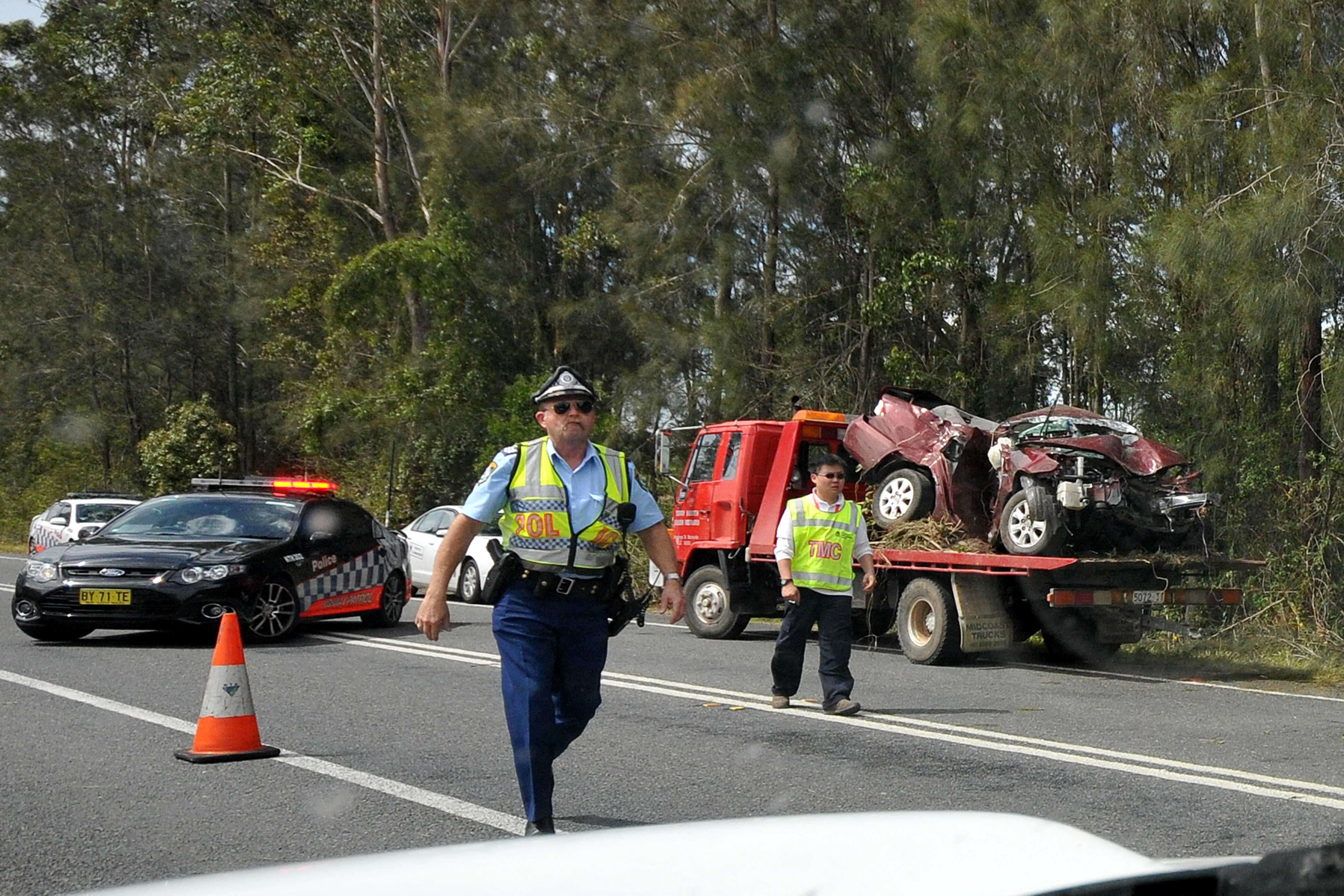 Police prepare to reopen the Pacific Highway after the wrecked vehicle has been loaded for removal. Police prepare to reopen the Pacific Highway after the wrecked vehicle has been loaded for removal.