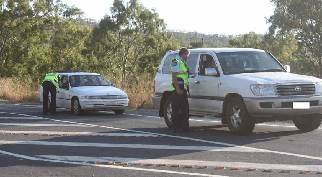ROAD BLOCK: Police officers speak to motorists travelling down the Mt Morgan Range while a gunman was on the loose yesterday. Inset: Fire crews were called to fight bushfires. ROAD BLOCK: Police officers speak to motorists travelling down the Mt Morgan Range while a gunman was on the loose yesterday. Inset: Fire crews were called to fight bushfires.