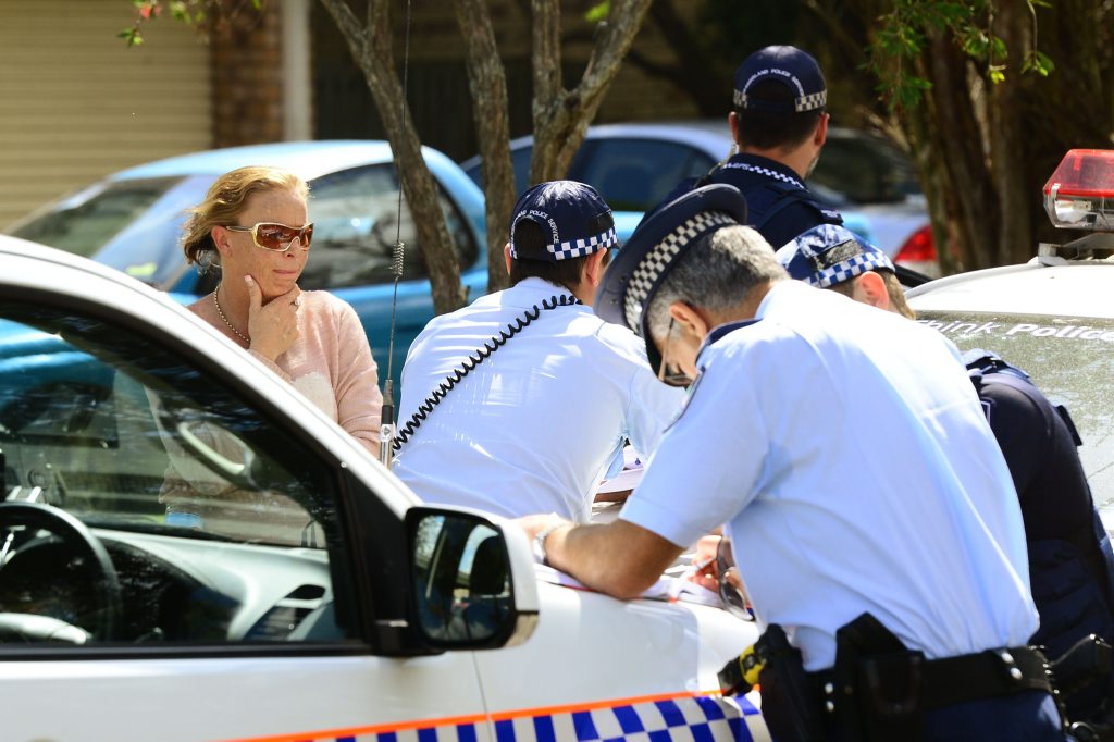 Emergency crews raced to the aid of a woman trapped beneath a car at a property in Redbank Plains. Police speak to neighbour Emily Downes (left) who helped at the scene. Photo: David Nielsen / The Queensland Times Emergency crews raced to the aid of a woman trapped beneath a car at a property in Redbank Plains. Police speak to neighbour Emily Downes (left) who helped at the scene. Photo: David Nielsen / The Queensland Times