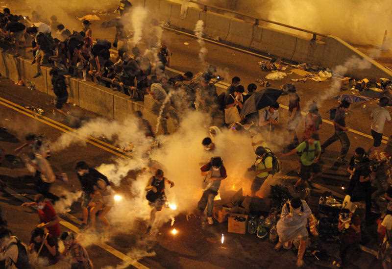 Riot police use tear gas against protesters after thousands of people blocked a main road at the financial central district in Hong Kong, Sunday, Sept. 28, 2014. Riot police use tear gas against protesters after thousands of people blocked a main road at the financial central district in Hong Kong, Sunday, Sept. 28, 2014.