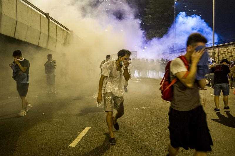 Protesters protect themselves from tear gas fired by police during riots that followed a pro-democracy protest in Hong Kong on September 28, 2014. Protesters protect themselves from tear gas fired by police during riots that followed a pro-democracy protest in Hong Kong on September 28, 2014.