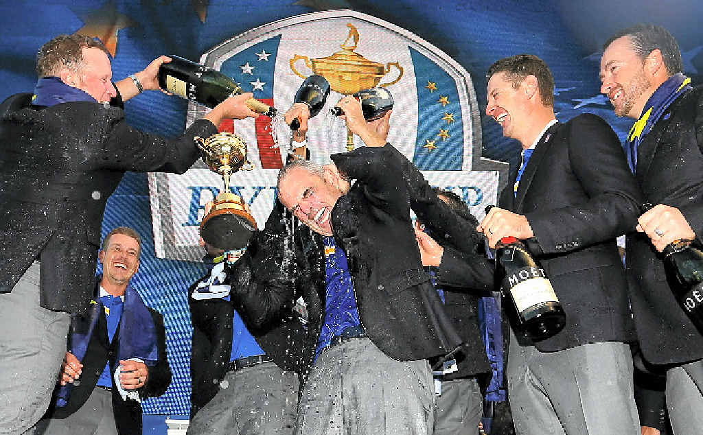 CHAMPAGNE MOMENT: Europe team captain Paul McGinley lifts the Ryder Cup trophy as he is sprayed with champagne by Jamie Donaldson (left). CHAMPAGNE MOMENT: Europe team captain Paul McGinley lifts the Ryder Cup trophy as he is sprayed with champagne by Jamie Donaldson (left).