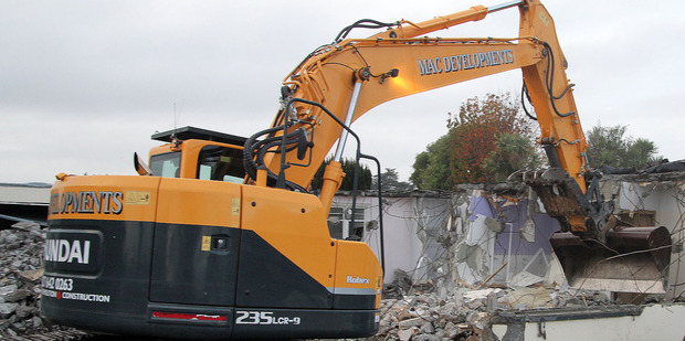 A digger demolishes a quake-damaged house. Abandoned and have become popular targets for burglars, thieves, and arsonists. A digger demolishes a quake-damaged house. Abandoned and have become popular targets for burglars, thieves, and arsonists.