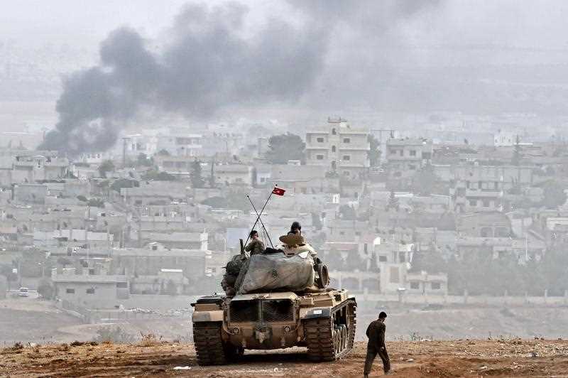 Turkish soldiers on a tank sit opposite the Syrian town of Ain al-Arab, known as Kobane by the Kurds, at the Turkish-Syrian border in the southeastern Turkish village of Mursitpinar, Sanliurfa province, on October 11, 2014. Turkish soldiers on a tank sit opposite the Syrian town of Ain al-Arab, known as Kobane by the Kurds, at the Turkish-Syrian border in the southeastern Turkish village of Mursitpinar, Sanliurfa province, on October 11, 2014.