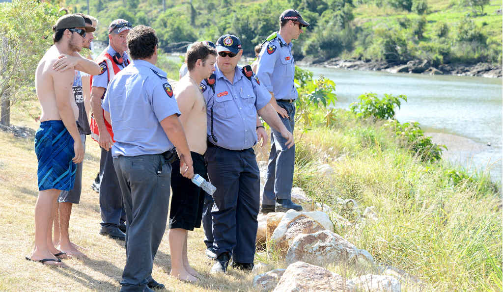 SWIMMING TRAGEDY: Swift water rescue personnel search for the man while crowds line the bank watching on. SWIMMING TRAGEDY: Swift water rescue personnel search for the man while crowds line the bank watching on.