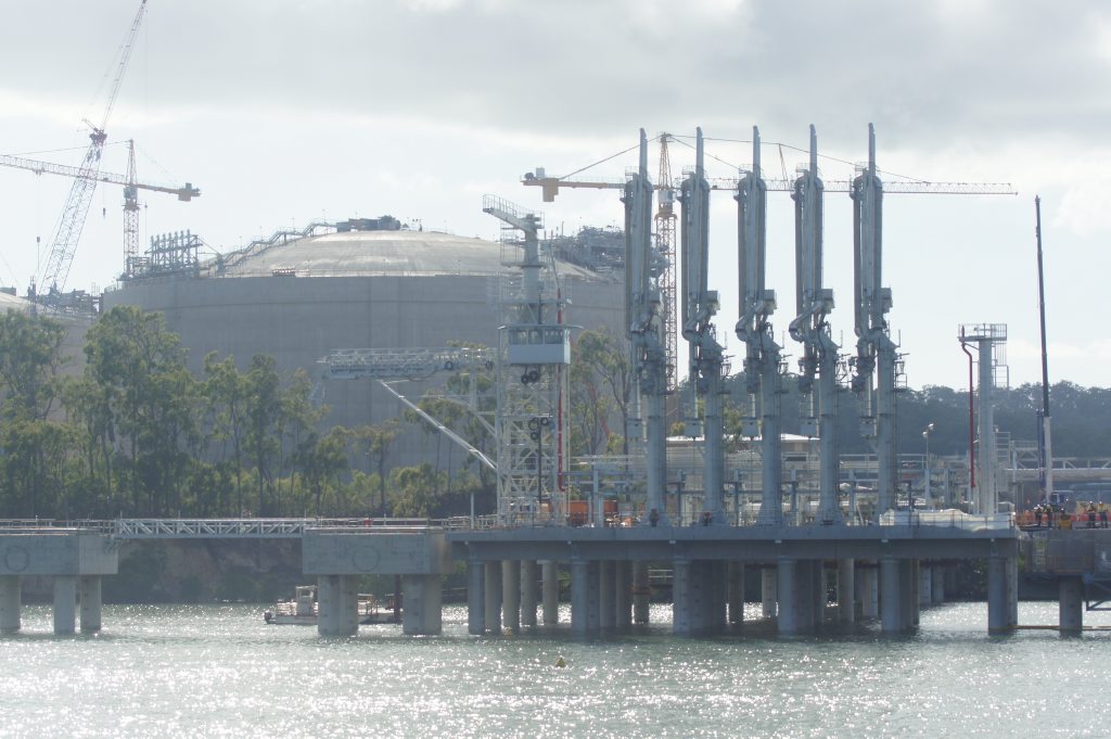 The APLNG site, including loading arms on the dock and an LNG tank, as seen from the quarterly construction cruise on Gladstone harbour, in May 2014. The APLNG site, including loading arms on the dock and an LNG tank, as seen from the quarterly construction cruise on Gladstone harbour, in May 2014.