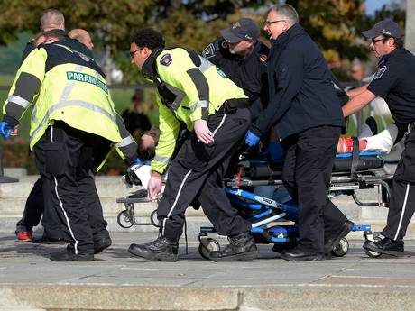 Paramedics and police pull a victim away from the Canadian War Memorial in Ottawa Paramedics and police pull a victim away from the Canadian War Memorial in Ottawa