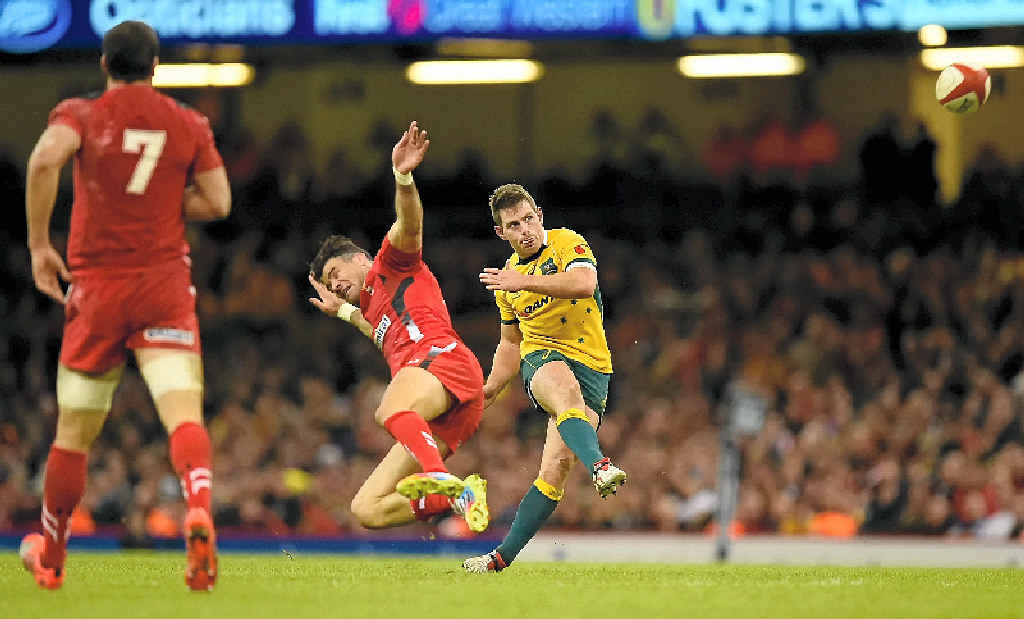 Wallabies fly half Bernard Foley kicks a drop goal despite the attentions of Mike Phillips. Wallabies fly half Bernard Foley kicks a drop goal despite the attentions of Mike Phillips.