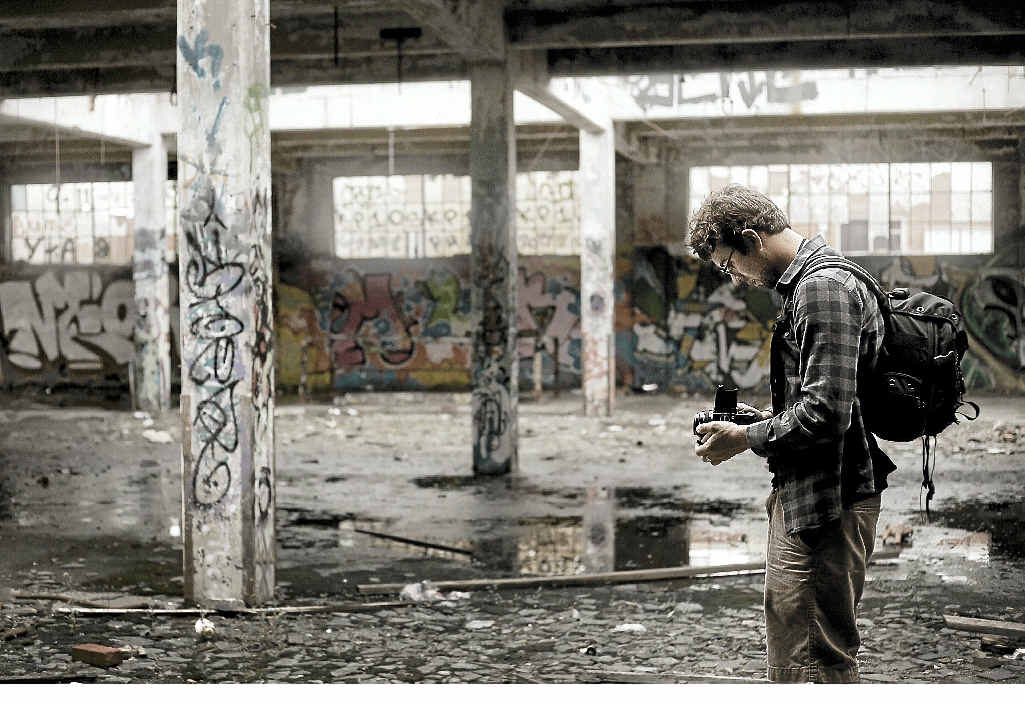 An urbexer takes pictures in an abandoned building. An urbexer takes pictures in an abandoned building.